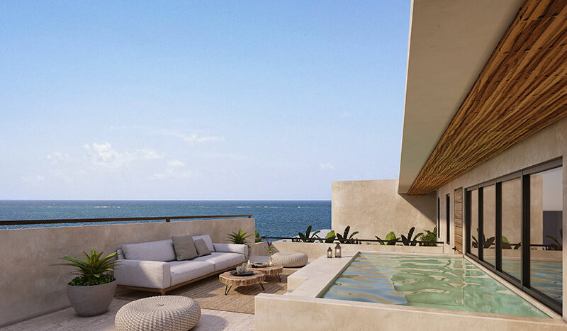 Terraza en el Condominio Nalu Luxury Beachfront Residences con vista al mar, mobiliario de exterior y áreas verdes.